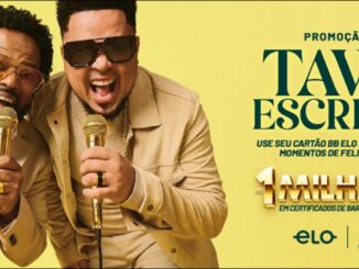 Dois cantores sorrindo com microfones dourados nas mãos, ao lado de um cartão BB Elo dourado, anunciando a promoção Tava Escrito com prêmio de R$1.000.000,00 em certificados de barras de ouro