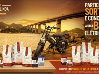Imagem promocional da Vista Linda Cafés Especiais mostrando produtos da marca dispostos ao lado de uma bike elétrica, com o mar, uma ponte e o pôr do sol ao fundo, anunciando sorteio de bikes elétricas nas Lojas Perim.