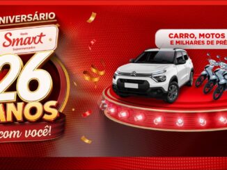 Banner da promoção de aniversário de 26 anos da Rede Smart Supermercados, com carro Citroën C3 0km e motos 0km expostos em um palco iluminado, sobre fundo vermelho festivo.