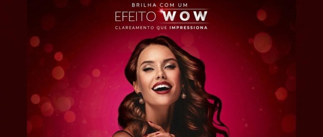 Desafio Luminous White Efeito Wow Peça publicitária do Desafio Luminous White Colgate com a frase "Brilha com um Efeito WOW – Clareamento que Impressiona" sobre fundo vermelho degradê, ao lado de mulher sorrindo com dentes brancos e cabelos castanhos ondulados.
