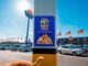 Banner do Especial Pet Assaí Atacadista fixado em pilar do estacionamento, com período de 17 a 21 de agosto, ao fundo a fachada da loja com bandeiras decorativas.
