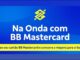 Arte da promoção Na Onda com BB Mastercard, do Banco do Brasil, com fundo azul, logotipo amarelo do banco e chamada para concorrer a viagens de surfe.