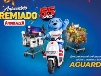 Banner da promoção Aniversário Premiado Supermercados Andreazza 55 Anos, com mascote canino azul sobre scooter branca, cercado de carrinhos de compras repletos de prêmios e alimentos, sobre fundo azul com balões e confetes coloridos.