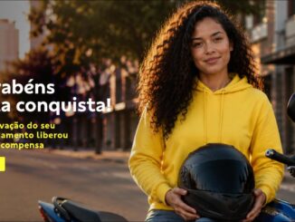 Mulher jovem com cabelos cacheados, usando moletom amarelo e segurando capacete preto, apoiada em moto azul em rua arborizada, com texto "Parabéns pela conquista! A aprovação do seu financiamento liberou uma recompensa" e botão "Saiba Mais".
