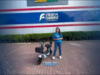 Promoção de Aniversário Frank Chaves Calçados: apresentadora ao lado de uma moto elétrica sorteada na campanha comemorativa de 44 anos da rede.
