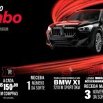 Banner da promoção Aniversário Mambo 44 anos com um BMW X1 preto sobre fundo escuro e rastros de luz vermelha, informando que a cada R$150,00 em compras o cliente recebe 1 número da sorte para concorrer ao carro.
