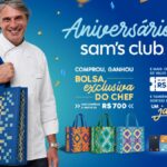Chef sorridente de dólmã branco segura uma bolsa quadriculada azul ao lado do título Aniversário Sam's Club, com três bolsas coloridas, vale-compras de até R$700 e sorteio final de um jantar.
