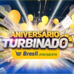 Banner da promoção Aniversário Turbinado Brasil Atacadista em Santa Catarina, com logotipo da rede, balões amarelos e vales-compra voando entre corredores de supermercado.