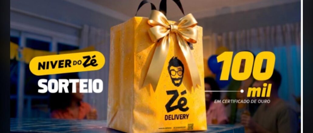 Sacola dourada do Zé Delivery com laço de fita dourada sobre uma mesa, ao lado do texto "Niver do Zé – Sorteio 100 mil em Certificado de Ouro".