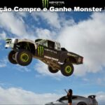 Caminhonete off-road com adesivos Monster Energy e Toyo Tires saltando no ar sobre um carro esportivo, com céu azul ao fundo e texto "Promoção Compre e Ganhe Monster Energy" no topo da imagem.