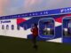 Estande da LATAM Airlines no Rock in Rio 2026, decorado com visual de fuselagem de avião nas cores azul, vermelho e branco, com a frase "A companhia aérea oficial de quem faz o show no Rock in Rio: O Fã" e logo LATAM Airlines no topo.