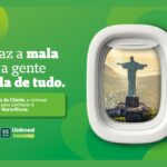 Peça publicitária da Unimed com fundo verde e janela de avião emoldurada mostrando o Cristo Redentor ao fundo, com a frase "Só faz a mala que a gente cuida de tudo", promovendo viagem ao Rio de Janeiro no Mês do Cliente, em celebração aos 55 anos da Unimed Vales do Taquari e Rio Pardo/RS.