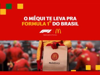 Banner vermelho da promoção do McDonald's com a frase "O Méqui te leva pra Formula 1 do Brasil", logotipos da F1 e do McDonald's e um integrante de equipe de boxe segurando uma sacola do McDelivery.