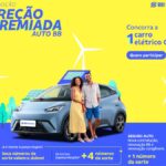 Peça publicitária da promoção Direção Premiada Auto BB, da BB Seguros, com casal posando ao lado de carro elétrico 0 km em cenário com turbinas eólicas e painel solar, sobre fundo amarelo e azul.