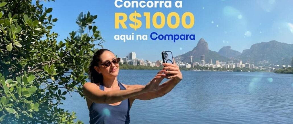 Mulher tira selfie à beira da Lagoa Rodrigo de Freitas, no Rio de Janeiro, com o Cristo Redentor ao fundo e o texto "Concorra a R$1000 aqui na Compara".