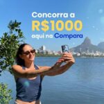 Mulher tira selfie à beira da Lagoa Rodrigo de Freitas, no Rio de Janeiro, com o Cristo Redentor ao fundo e o texto "Concorra a R$1000 aqui na Compara".