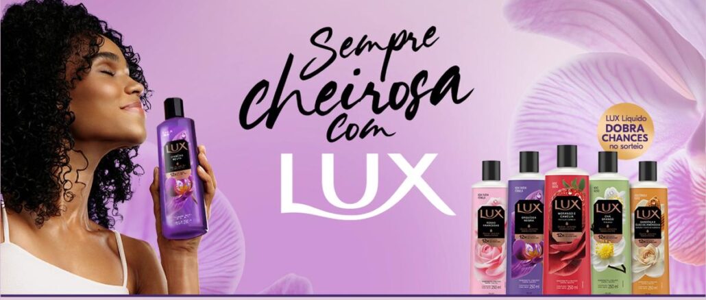 Promoção Sempre Cheirosa com Lux Banner da promoção Sempre Cheirosa com Lux, com mulher de cabelos cacheados segurando um sabonete líquido Lux Orquídea Negra e cinco frascos da linha Lux ao lado, com selo indicando que Lux Líquido dobra as chances no sorteio.