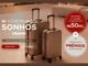 Banner da promoção Eliane Construindo Sonhos com duas malas de viagem em tom bronze sobre piso claro, destacando uma grande viagem de até R$50 mil e centenas de prêmios instantâneos.