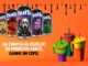 Cinco latas de Fanta de 350 ml com personagens de terror ao lado de três copos coloridos com alça e canudo, sobre fundo laranja, com o texto: na compra de R$20,00 em produtos Fanta, ganhe um copo.