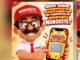 Mascote Benezim, das Lojas Noroeste, de boné vermelho, óculos e bigode, mostra no celular a raspadinha virtual do Aniversário Noroeste com a mensagem "Parabéns! Você ganhou!" e o aviso de mais de 2 mil prêmios.
