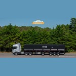 Caminhão prata com semirreboque graneleiro preto da Linha New R diante de uma mata verde, sob o selo "Promoção Conquista Premiada II".