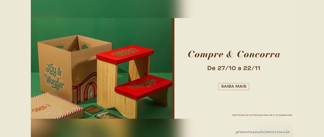 Banner natalino com uma escada de madeira de dois degraus pintados de vermelho com a inscrição Joy & Wonder, ao lado de uma caixa de papelão e embalagens, sobre fundo verde, e o texto Compre & Concorra, de 27/10 a 22/11.