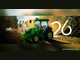 Duas produtoras rurais olham o celular em meio ao cafezal, ao lado de um trator John Deere verde cabinado, com o logotipo ofi Direct, os dizeres Sorteio 5ª Edição e o número 26