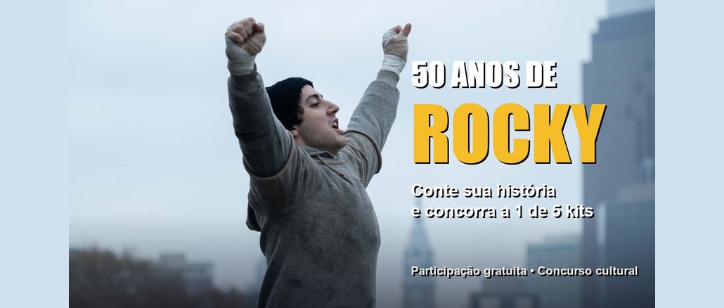 Cena de "Eu Sou o Rocky" com o ator Anthony Ippolito, como Sylvester Stallone, de braços erguidos e mãos enfaixadas, com o texto "50 anos de Rocky: conte sua história e concorra a 1 de 5 kits".