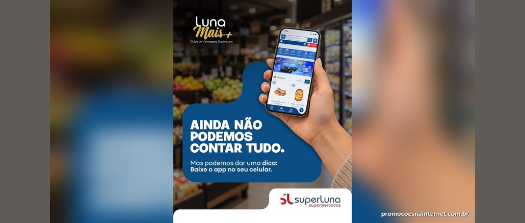 Promoção Fim de Ano SuperLuna Mão segurando um celular com o aplicativo SuperLuna aberto ao lado do texto "Ainda não podemos contar tudo. Mas podemos dar uma dica: baixe o app no seu celular", em um corredor de hortifruti, com as marcas Luna Mais+ e SuperLuna Supermercados.